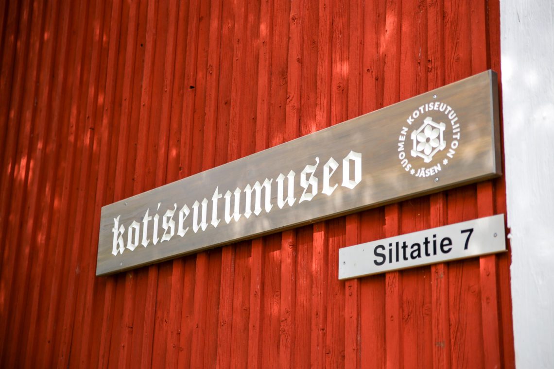 Kotiseutumuseon logo- ja osoitekyltti museon ulkoseinällä