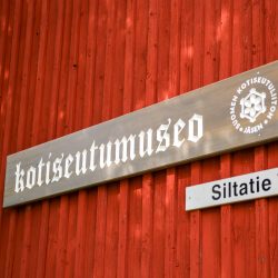 Kotiseutumuseon logo- ja osoitekyltti museon ulkoseinällä
